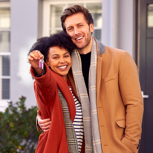 Happy couple in front of their new home