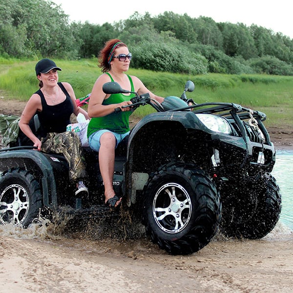 Friends ride ATV through lake