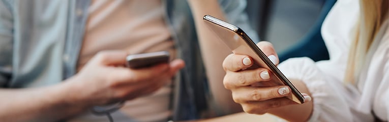 Two people on their phones check their financial accounts with Peach State.