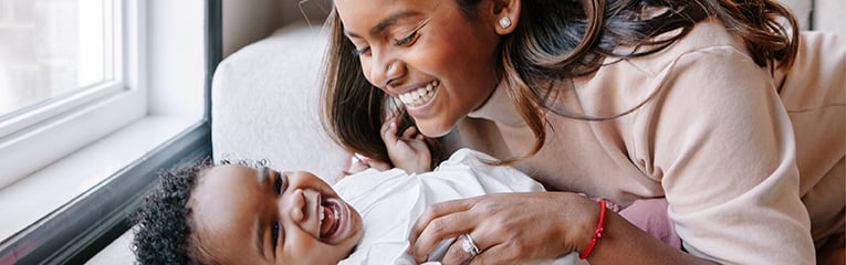 A woman with her baby smile knowing Peach State has their financial security in mind.