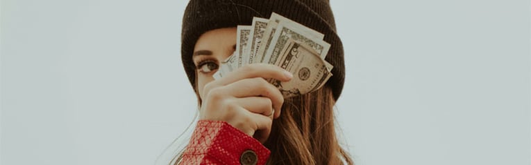 52-week-money-challenge-can-help-boost-your-savings-woman-with-cash-near-her-face