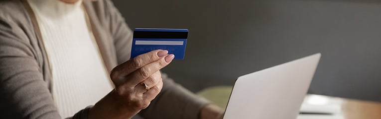 Close up mature woman making internet payment, holding plastic card