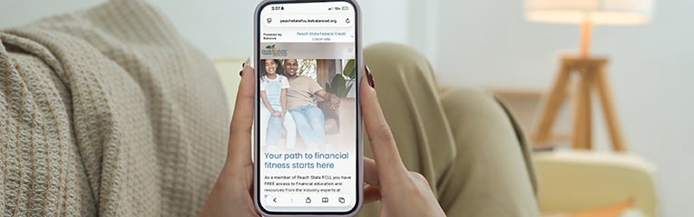Close up shot of woman holding mobile phone with blank screen lying on sofa at home