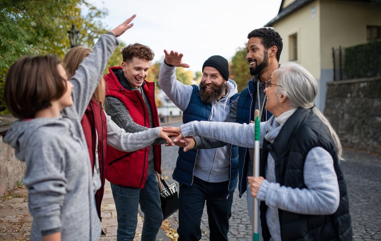Diverse group of happy volunteers with hands putting hands in a circle