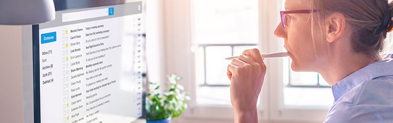 Female business person reading email on computer screen at work