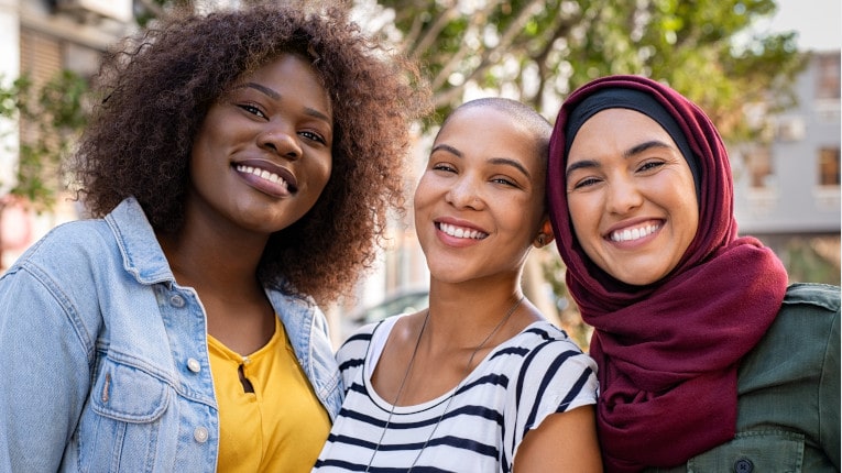 Group of three multiethnic young ladies smiling