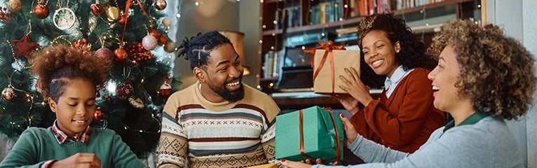 Happy black multi-generation family exchanging gifts at Christmas.