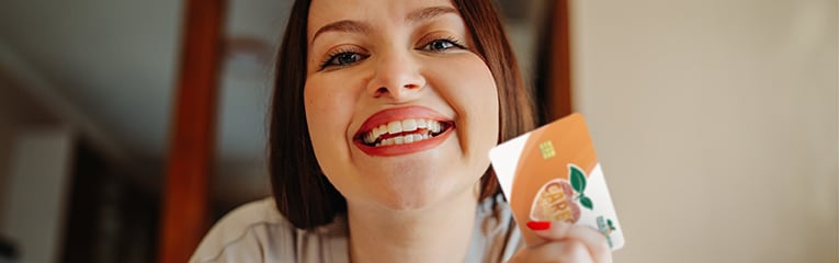 Happy woman holding blank credit card for online shopping