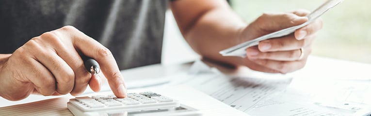 Man using calculator and looking at bills