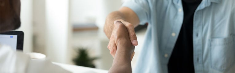 Man-refinanced-his-car-loan-and-is-shaking-credit-union-loan-officers-hand-to-thank-him.