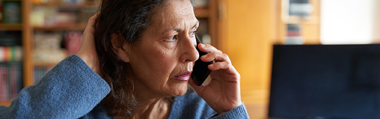 Stressed senior businesswoman on the phone while working on laptop stock photo