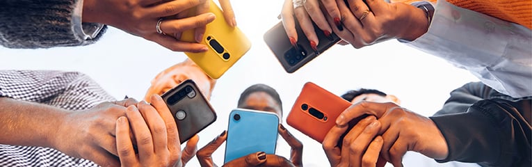Teens in circle holding smart mobile phones