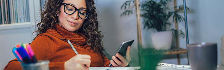 Woman holding phone in her hands, calculating family budget at home