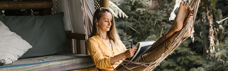 Woman reading a book in a hammock