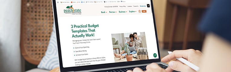 Woman using and typing on laptop computer with blank white desktop screen