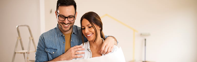 Young couple looking at blueprint