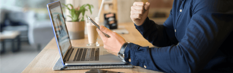 man on computer and phone