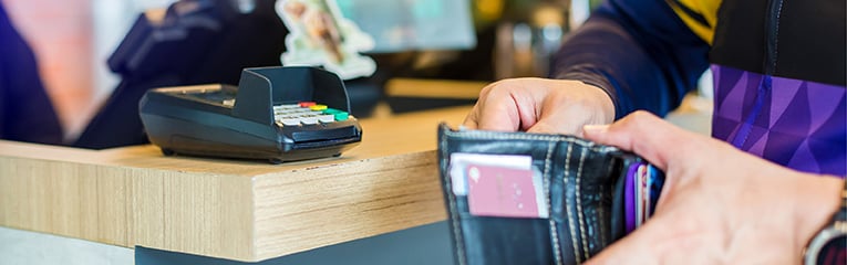 man picking up banknotes or credit card in the wallet to pay at the counter service