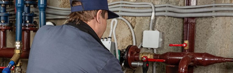 review-your-basement-and-water-issues-with-home-inspection-peach-state-is-here-to-help-man-in-basement-checking-pipes