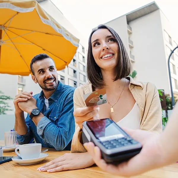 Woman smiles while tapping to pay with PSFCU visa debit card
