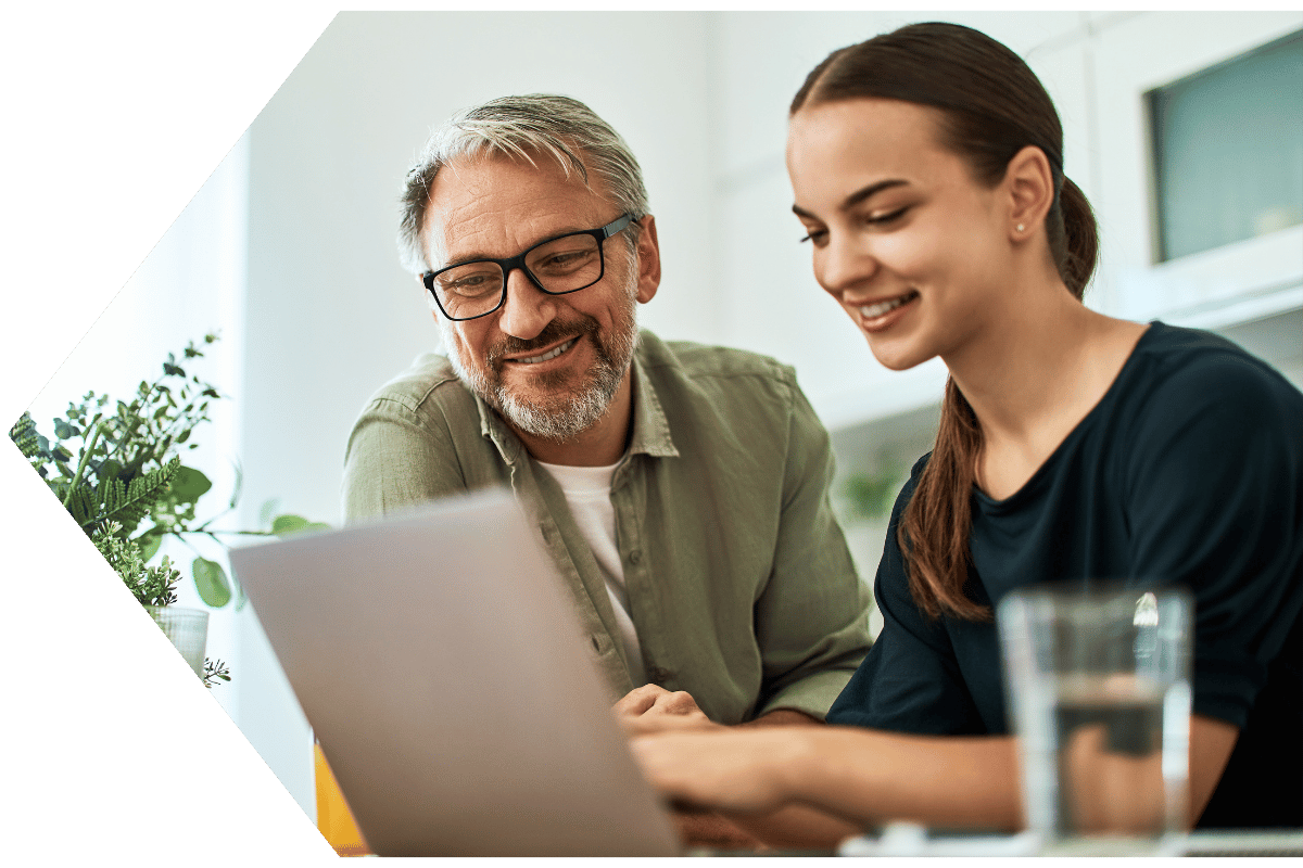 Father and daughter paying bills online with online banking at Peach State FCU