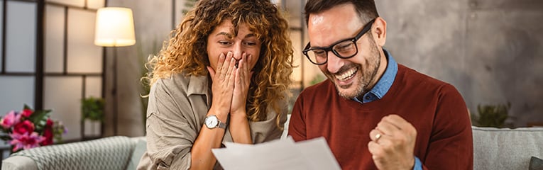 Happy couple read the good news in the post envelope letter at home-1