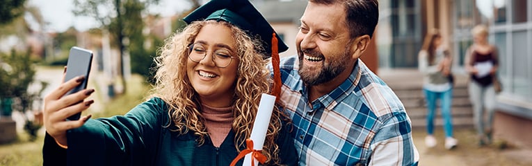 Happy student taking selfie with her father on her graduation day