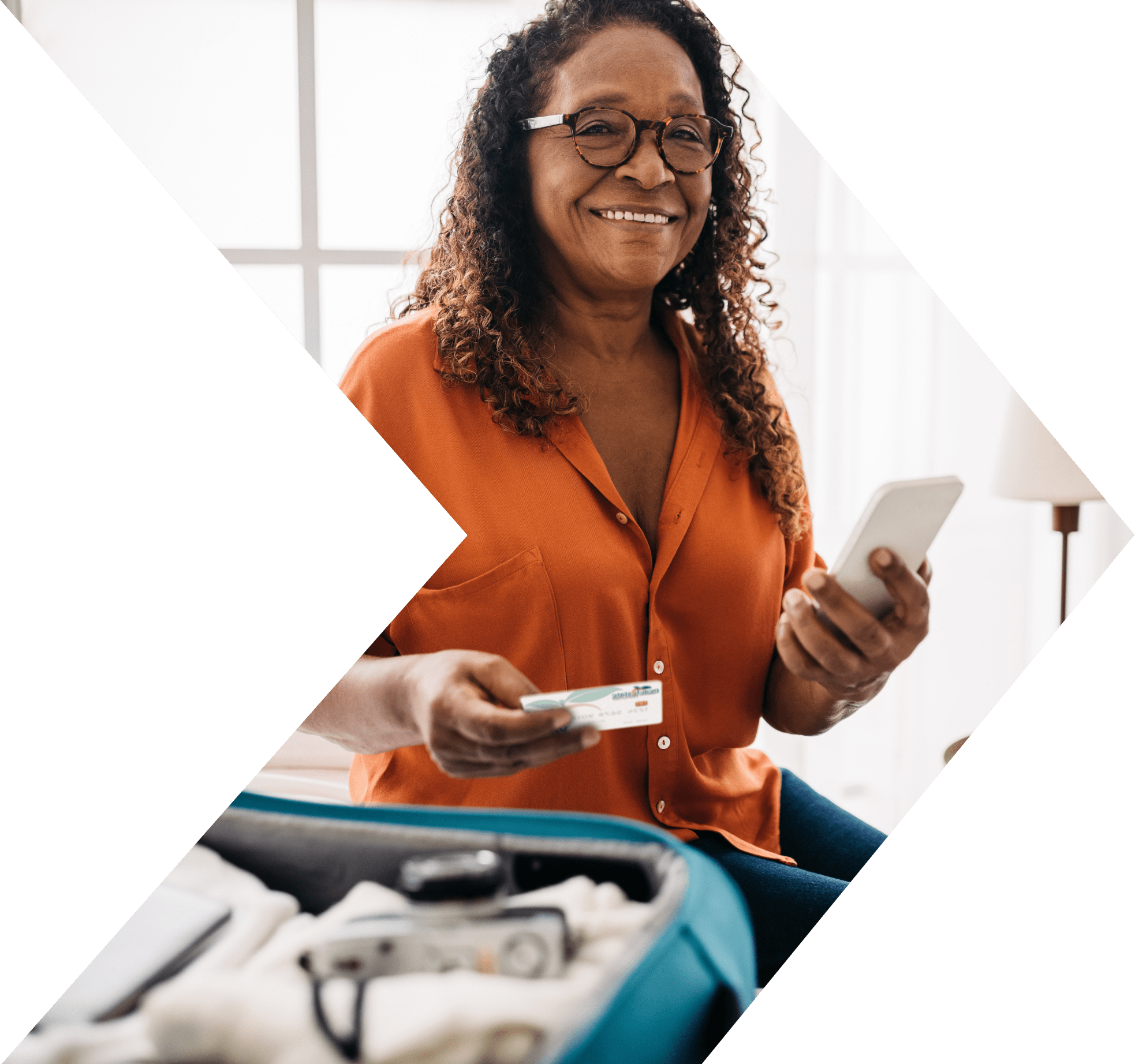 Middle aged african american woman siles while holding cc and packing