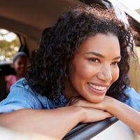 Woman smiles outside car window