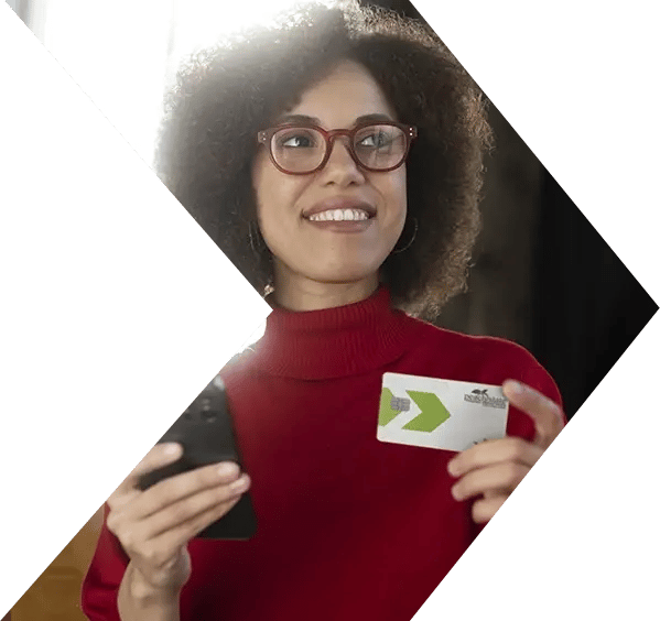 Woman smiles after making purchase on phone with PSFCU visa credit card Woman smiles after making purchase on phone with PSFCU visa credit card