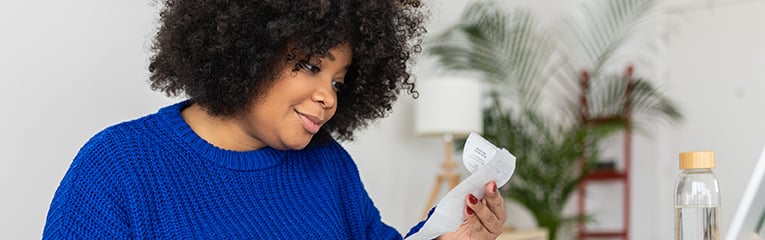 Young african american with laptop computer managing budget and expenses bills at home.
