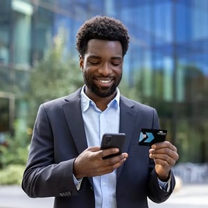 Young businessman makes purchase on phone using PSFCU business visa credit card