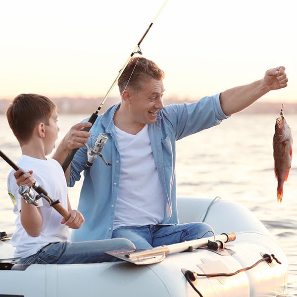 Father and son catch fish on boat