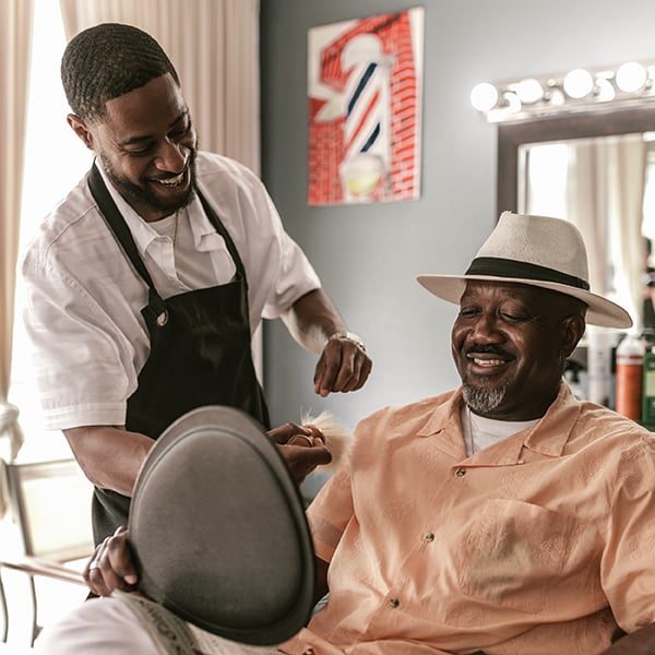 Barber laughs with customer