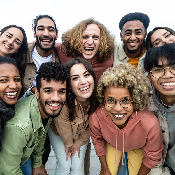 A diverse group of people with Checking Accounts at Peach State FCU smile at the camera.