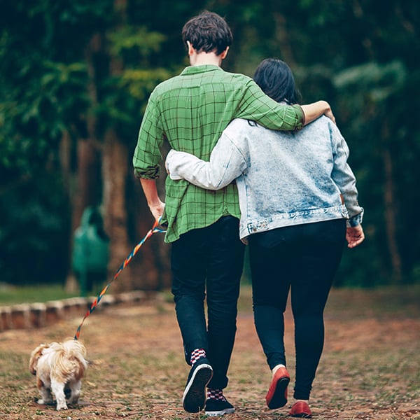 Couple walks trail with their dog