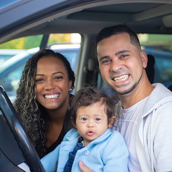 Family poses in their vehicle