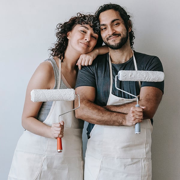 Young couple holding paint rollers