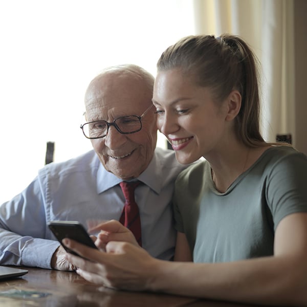 Granddaughter shows grandpa how to use mobile banking
