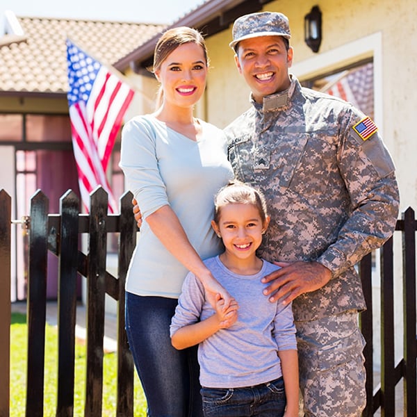 Military family poses outside home