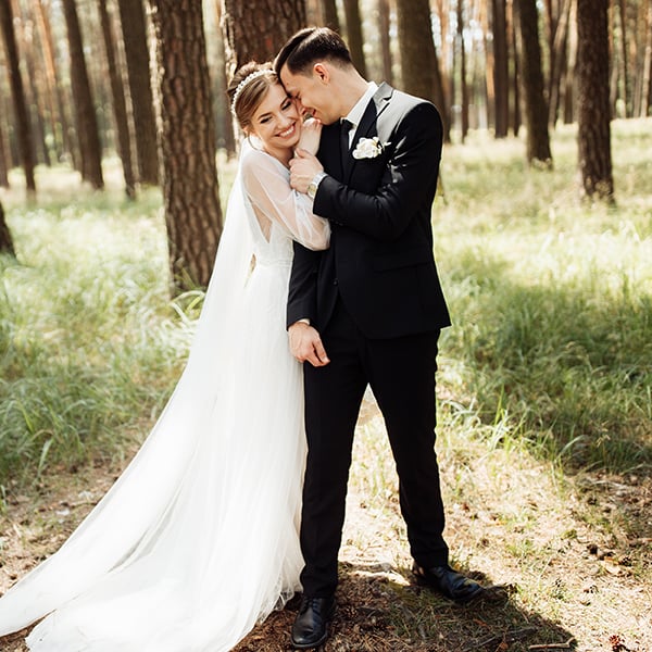 Young married couple poses in woods