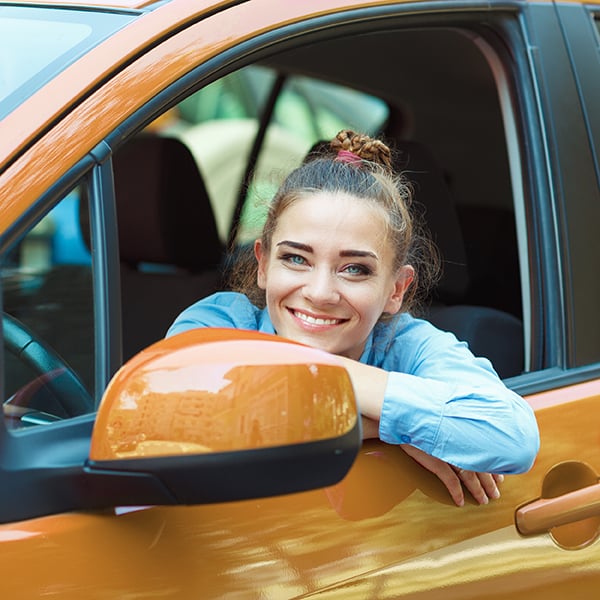Young woman smiles in her car