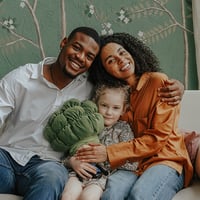 Family smiles together on living room sofa