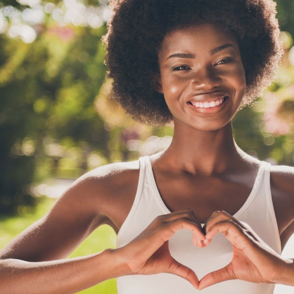 A woman with a Peach State Business Credit Card holds her hands up in a heart.
