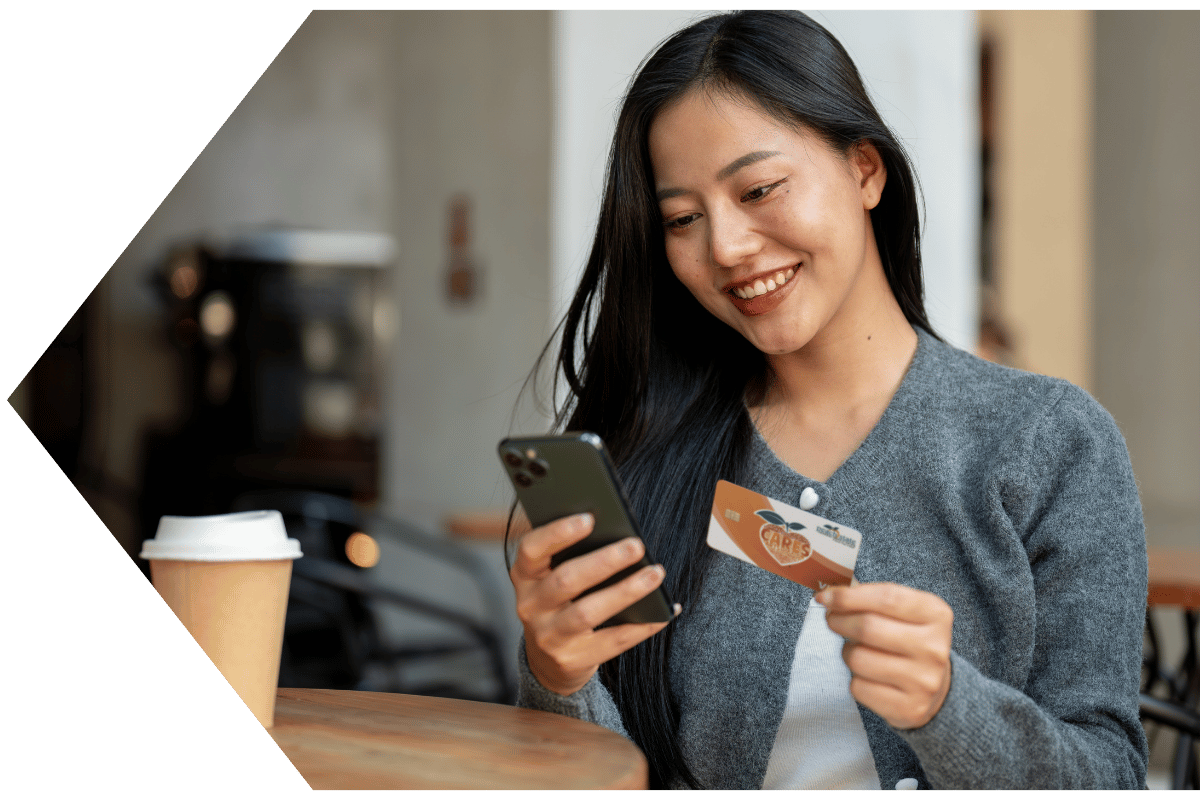 young asian woman uses her Peach State FCU debit card with confidence and overdraft protection