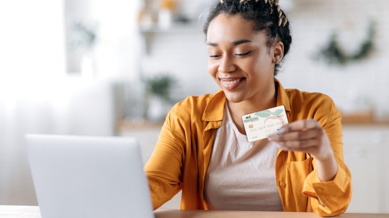 A young woman uses her Peach State Credit Card to shop online