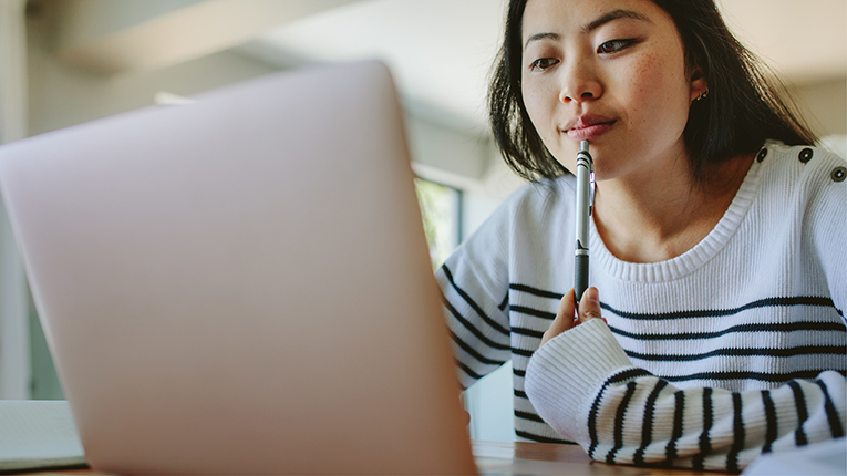 Asian woman studying at home using laptop