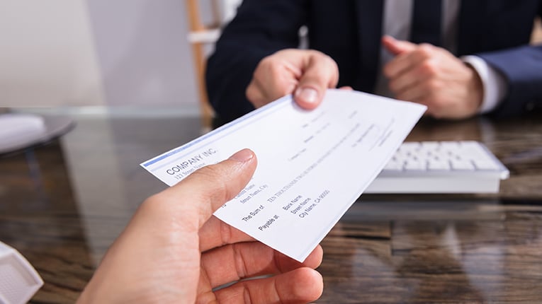 credit union employee hading a member a cashiers check