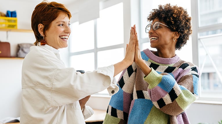 Colleagues celebrating success in a modern co-working space