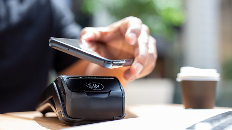 person paying with phone, tap to pay option